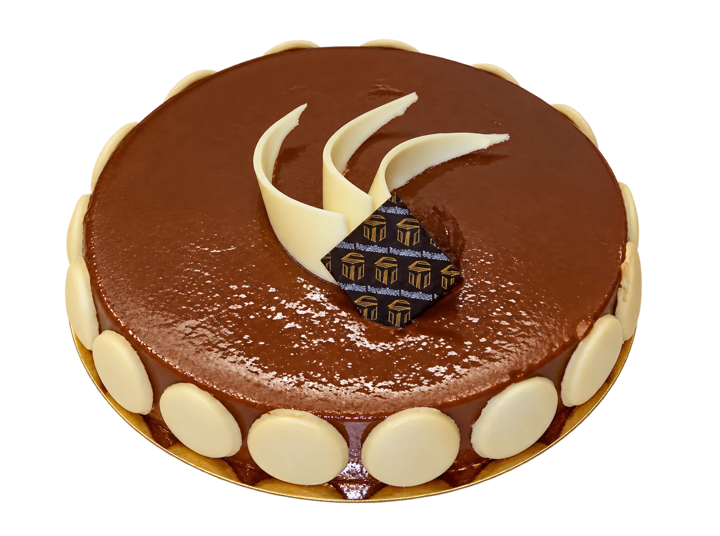 Gâteau rond au chocolat saupoudré de cacao, entouré de biscuits ronds et décoré de copeaux de chocolat blanc et d'une plaquette de chocolat ornée de motifs.