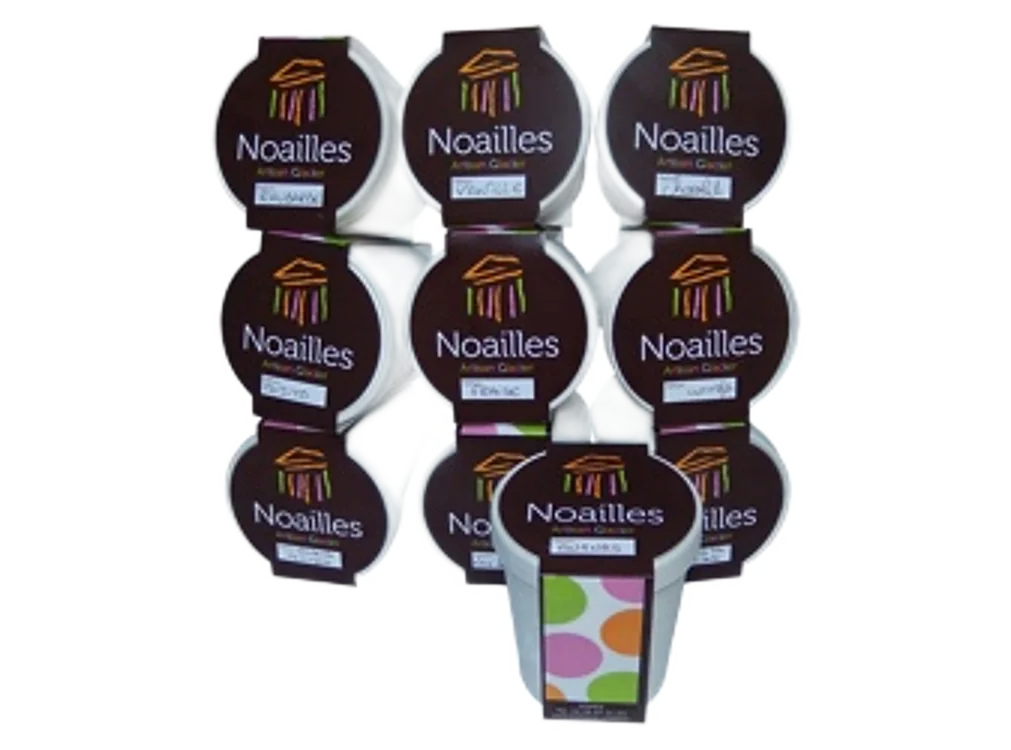 Plusieurs pots blancs de la marque Noailles, ornés d'une étiquette marron et d'un logo coloré, sont empilés sur un fond blanc uni.